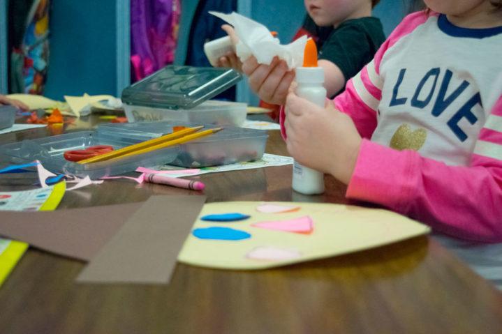 Two children gluing a project