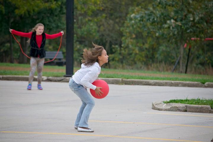 Lakeview Elementary Female students at recess one with a Red Ball one with red jump rope